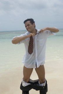 Hispanic businessman stripping at beach