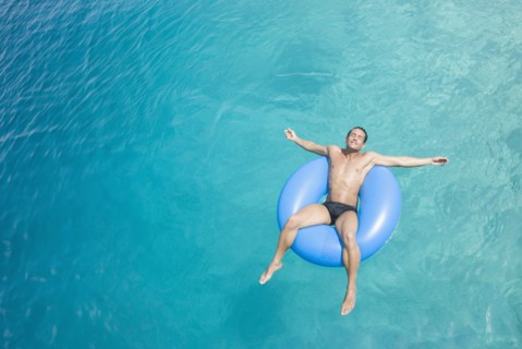 Hispanic man on float in water