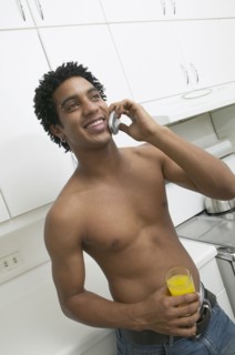 Bare-chested African man talking on cell phone
