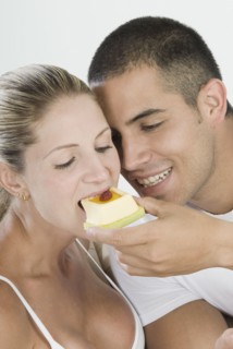Hispanic man feeding girlfriend dessert