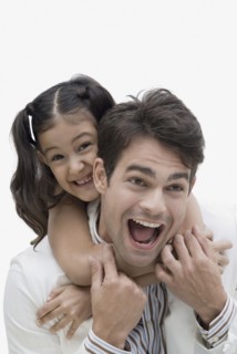 Hispanic father giving daughter piggyback ride