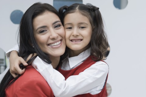 Hispanic mother hugging daughter