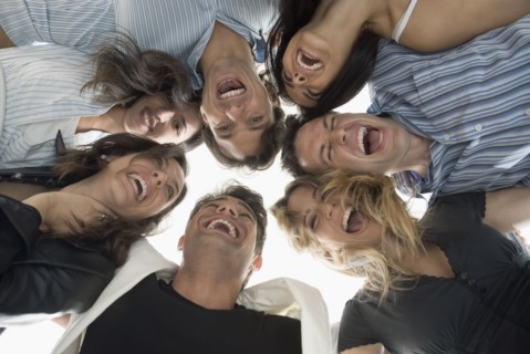 Laughing Hispanic friends hugging