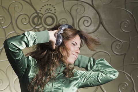 Hispanic woman in headphones dancing