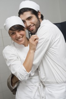 Bakers hugging in bakery kitchen