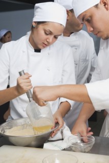 Bakers stirring batter in bakery kitchen