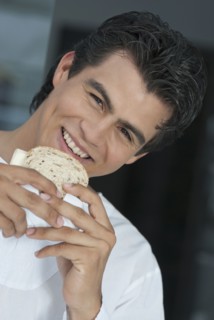 Hispanic man eating sandwich