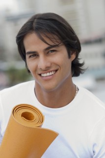 Hispanic man holding yoga mat