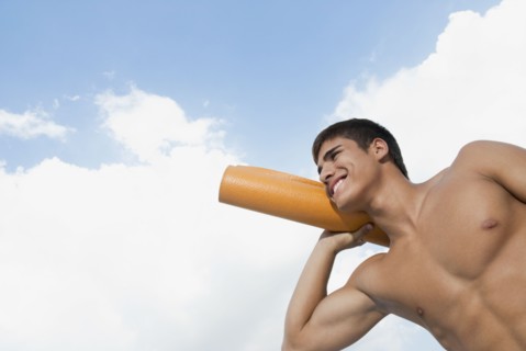 Smiling Hispanic man carrying yoga mat