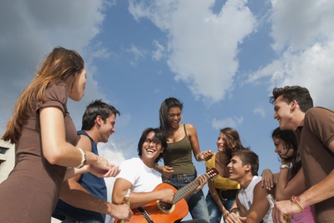 Friends listening to man playing guitar
