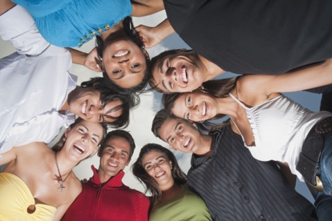 Smiling friends in huddle together