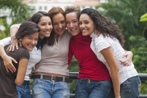 Smiling Hispanic women hugging