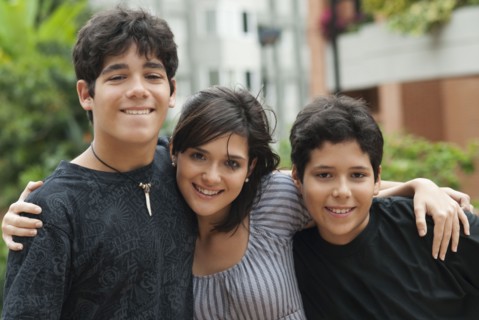 Hispanic mother and sons hugging