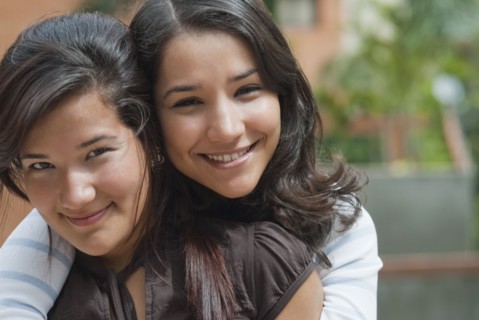 Hispanic sisters hugging