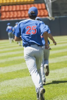 Hispanic baseball player running on field