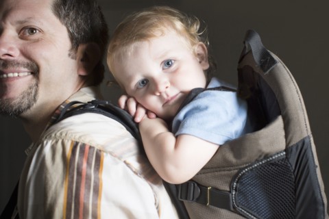 Caucasian father carrying son on back