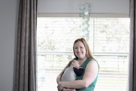 Mother holding baby son at window
