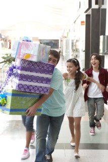 Hispanic friends carrying gifts in shopping mall