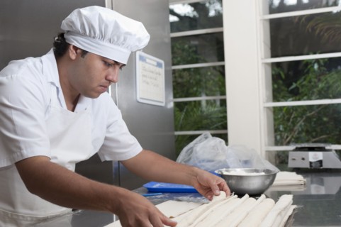 Hispanic baker working in commercial kitchen