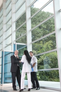 Hispanic businessman talking to doctor in lobby