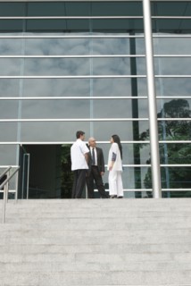 Hispanic business people talking to doctor on steps
