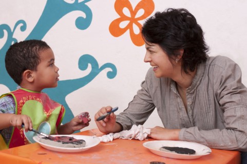 Hispanic mother painting with son