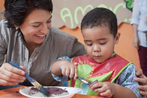Hispanic mother painting with son