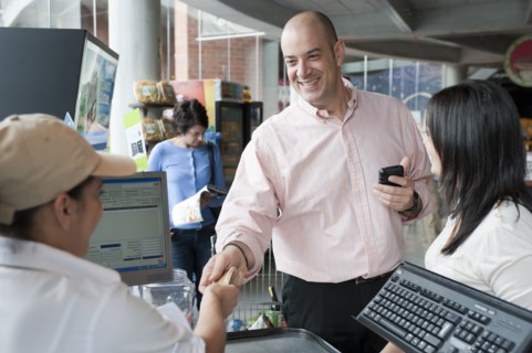 Hispanic man paying with credit card in store