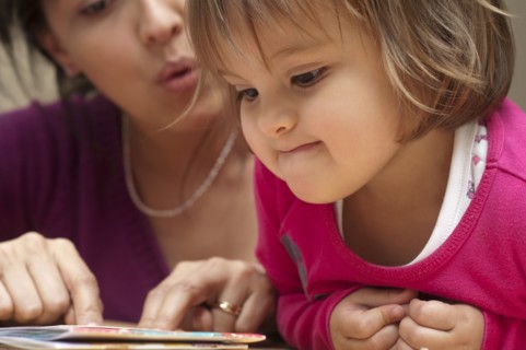 Hispanic mother reading book to daughter