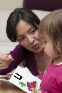 Hispanic mother teaching daughter alphabet