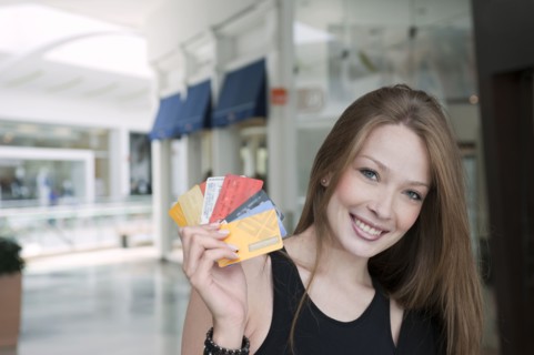 Hispanic woman holding credit cards in mall