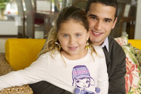 Hispanic girl sitting on father's lap