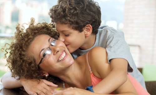 Hispanic boy kissing mother