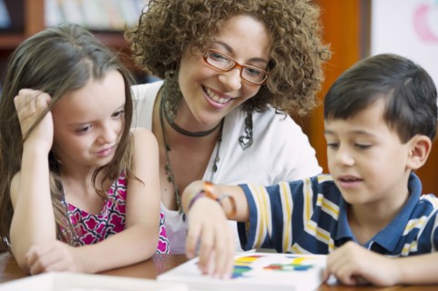 Hispanic teacher helping students