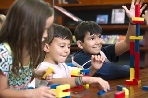 Hispanic students in library playing with blocks