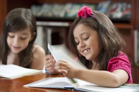 Hispanic girls reading in library