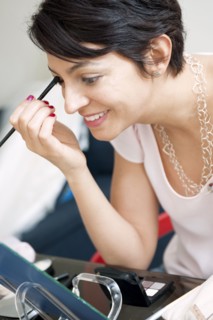 Smiling woman applying make up