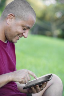 Hispanic man using tablet computer