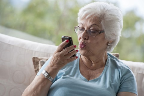 Hispanic woman making kissy face at cell phone