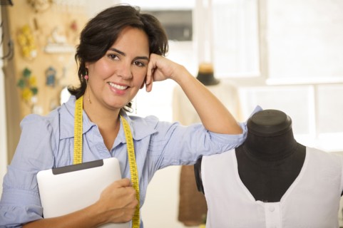 Hispanic dressmaker smiling in studio