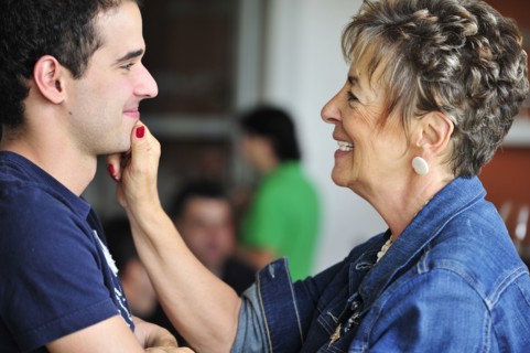 Hispanic grandmother pinching grandsons face