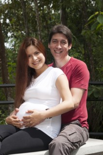 Mixed race expectant couple hugging outdoors