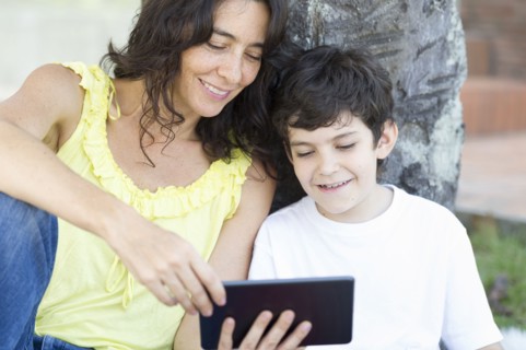 Hispanic mother and son reading digital tablet