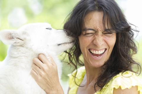 Hispanic woman playing with dog