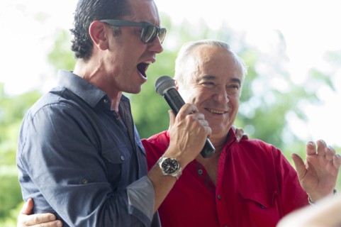 Grandfather and grandson talking into microphone at family reunion