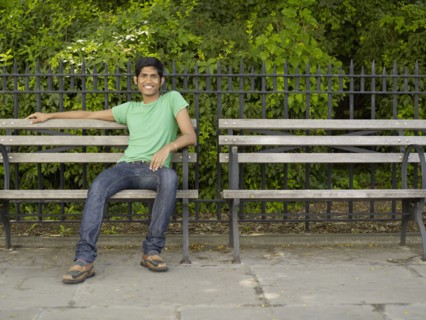 Indian man relaxing on park bench