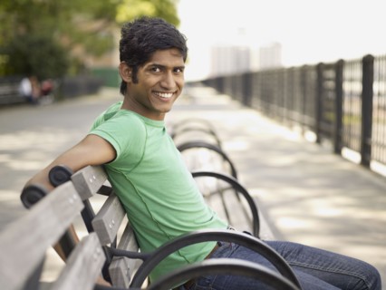 Indian man relaxing on park bench