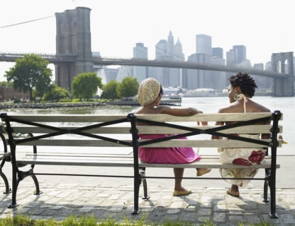African women sitting on bench at urban waterfront