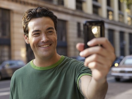 Man taking photograph with cell phone
