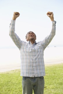 Young mixed race man with arms raised